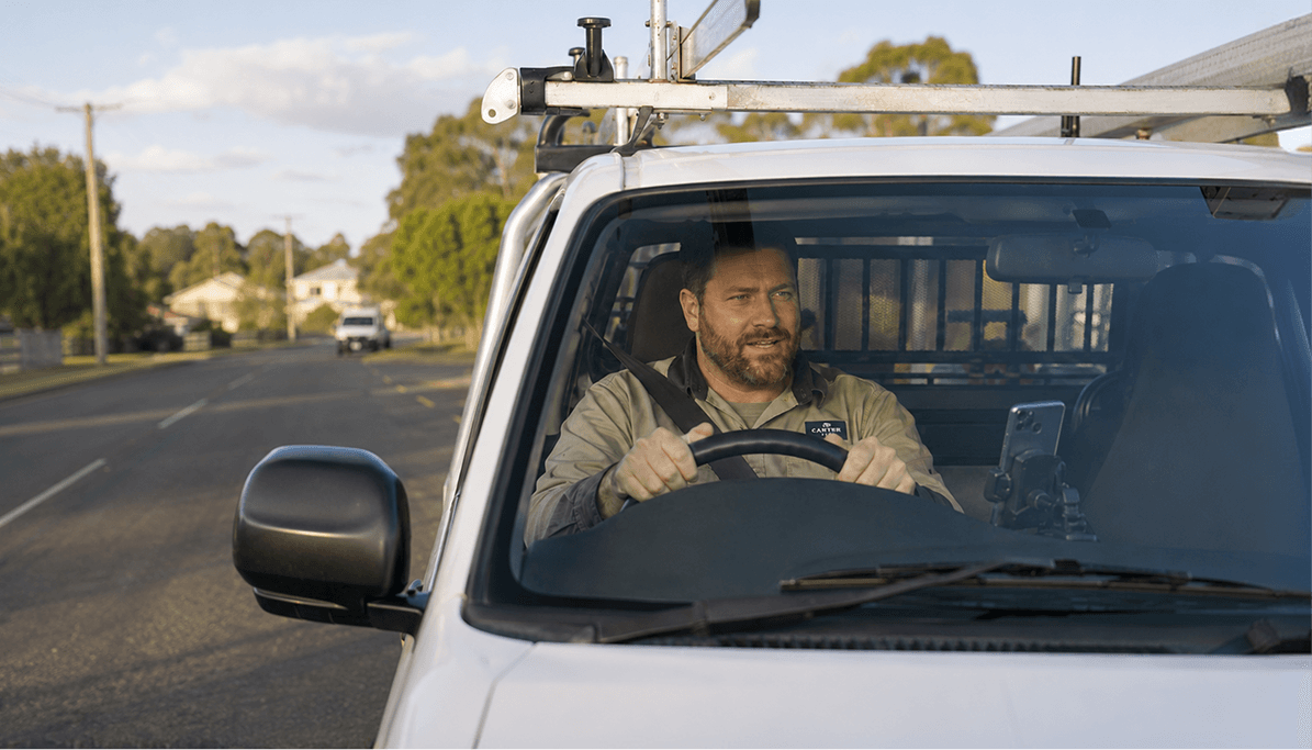 A tradesperson driving a work ute